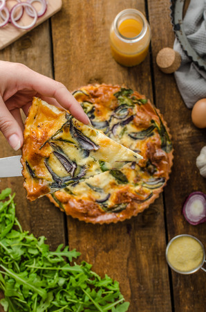 Polenta quiche with red onion, spinach, mozzarella and arugulaの写真素材