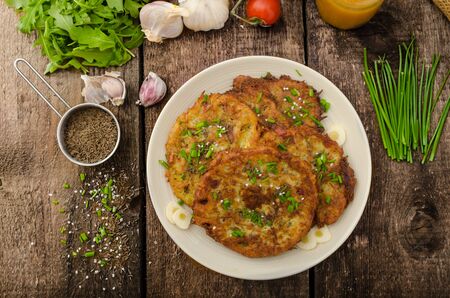 Fried potato pancakes with garlic and marjoram, sprinkled cumin, chive and coarse-grained saltの写真素材