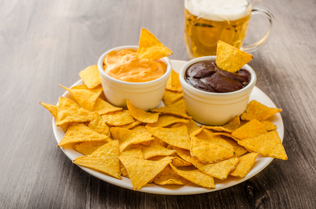 Tortilla chips with cheese dip and barbecue, czech beerの写真素材