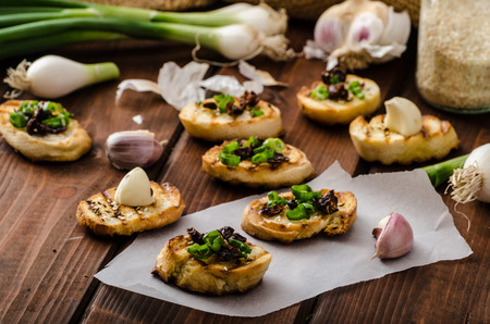 Mini toasts with garlic and dried tomato, sprinkled with herbsの写真素材