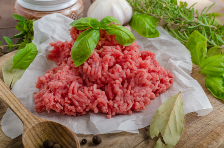Minced beef raw on wood table with herbs and spiceの写真素材