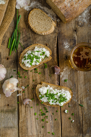 Homemade bread with spread - fresh cheese with garlic and chiveの写真素材