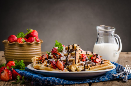 Original Belgian waffles, sprinkled sugar and strawberries, little chocolate, milk drink.の写真素材