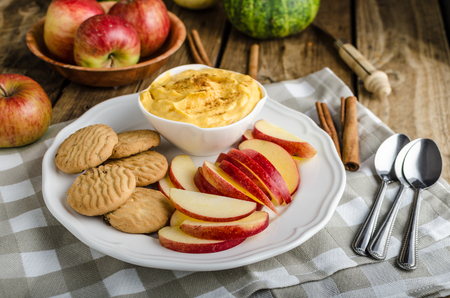 Pumpkin dip with cinnamon, homemade biscuits and a delicious apple slicesの写真素材