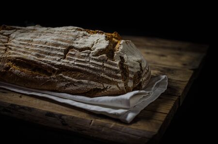 Home-baked sourdough bread, wheat-rye rustic, product photo, ready for your dark advertisment, place...