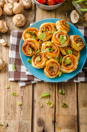Pizza snails in puff pastry with ham, cheese and mushroomsの写真素材