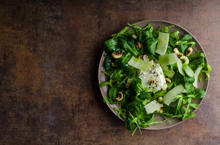 Fresh salad of arugula and lamb lettuce, baked nuts and cheeseの写真素材