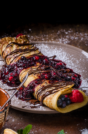 Delicious crepes with forest fruit, topped and filled with forest fruit, mint and dark chocolate, delicious breakfastの写真素材