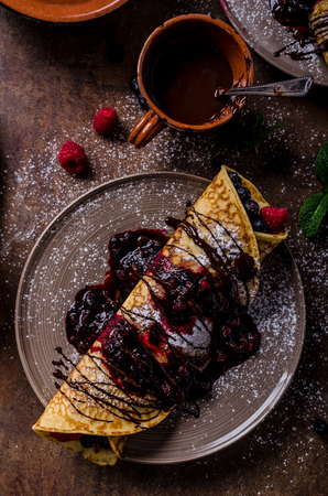 Delicious crepes with forest fruit, topped and filled with forest fruit, mint and dark chocolateの写真素材