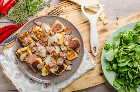 Home baked gnocchi with bacon and parmesan, fresh salad behindの写真素材
