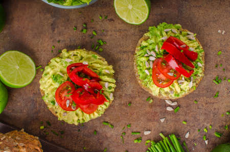 Whole wheat bread with avocado butter, seeds and pepper, with herbs and little juice from lime
