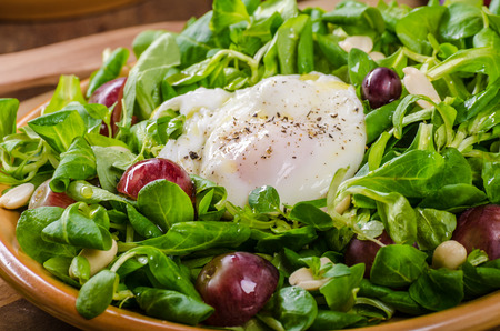 Lamb lettuce salad with poached egg, nuts and grapes, simple, healthy and delicious!の写真素材