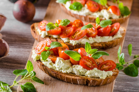 Fresh cheese panini bread with herbs, cherry tomatoes, simple and delicious snack!の写真素材