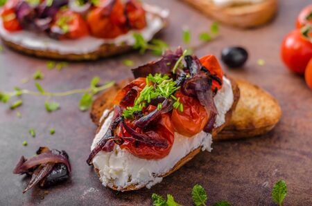 Toast with roasted vegetable, fresh cheese, roasted red onion and tomatoes, fresh olives and herbsの写真素材