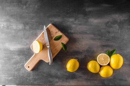 Fresh lemons photo, cutting board with chef knife, place for textの写真素材