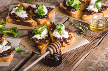 Rustic toast with caramelized onion, goat cheese, garlic and herbsの写真素材