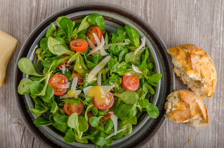 Lamb lettuce salad with dijon dressing, crispy bun and parmesan cheese on topの写真素材