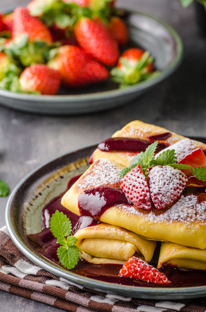 Filled pancakes with strawberries, fresh berries and sauceの写真素材