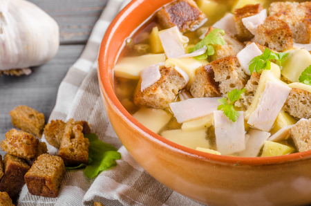 Garlic soup with cheese, ham and croutonsの写真素材