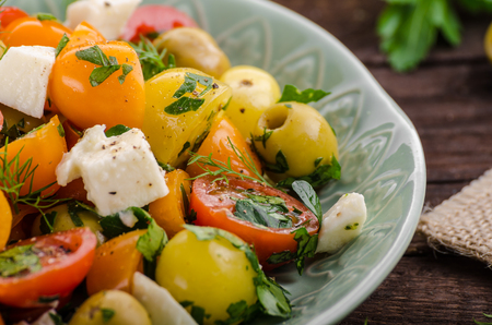 Fresh tomato olives salad, herbs and feta cheese insideの写真素材