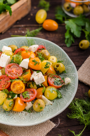 Fresh tomato olives salad, herbs and feta cheese insideの写真素材