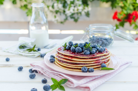 delish breakfast with fresh fruit on garden party, outside with flowers behind and fresh herbs on topの写真素材