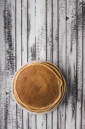 Homemade crepes with frozen berries, topped sugar, rustic wood boardの写真素材