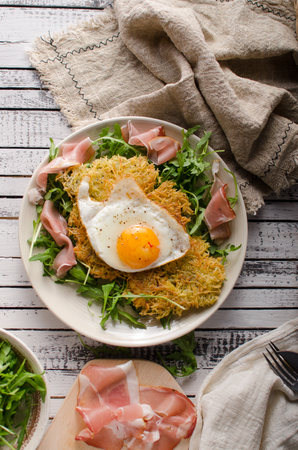 Potato pancakes with eggs and ham, fresh arugula saladの写真素材