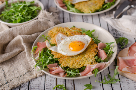 Potato pancakes with eggs and ham, fresh arugula saladの写真素材