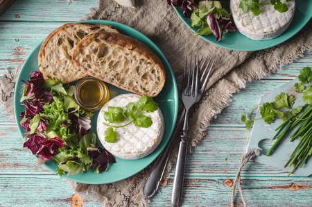 Delicious cheese, fresh salad and herbs with honeyの写真素材