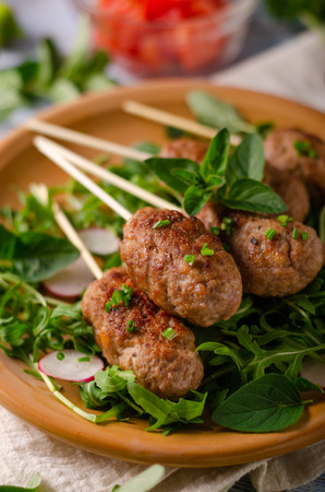 Hot and spicy delicious meat, grilled with fresh garlic and herbs, fresh saladの写真素材