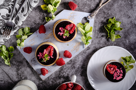 Fresh and simple dessert with fresh berries, dark chocolate cookie on top and fresh creame in middleの写真素材