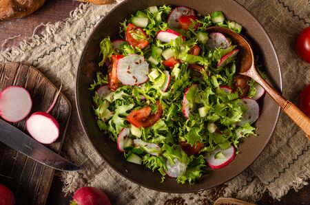 Lettuce salad with radishes, tomatoes, cucumber and fresh bunsの写真素材