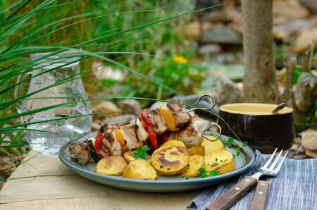 Outside grilling near beautiful garden with pondの写真素材