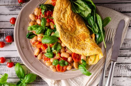 Heathy omelette with tomatoes, fresh herbs and beans, french onionの写真素材