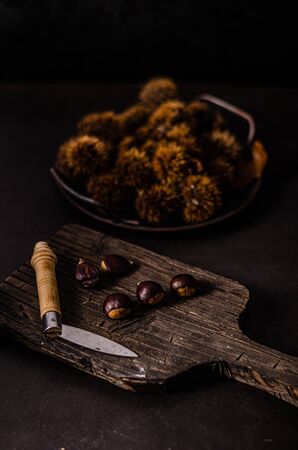 Chestnuts product photography with old knife and cutting boardの写真素材