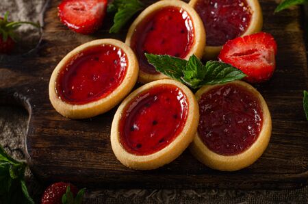 Delicious crispy tartlets with fresh strowberries jam and mintの写真素材