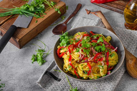 Organic bio pasta with curry chicken and fresh vegetableの写真素材