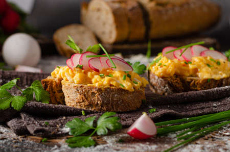 Fresh homemade bread with scrambled eggs and crispy radishes