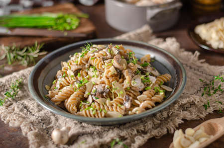 Original creamy pasta with mushrooms, herbs and almond slicesの写真素材