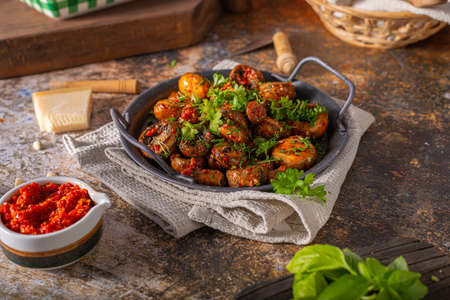 Roasted mushrooms and chilli sauce topped with herbsの写真素材