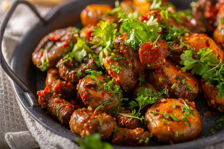 Roasted mushrooms and chilli sauce topped with herbsの写真素材