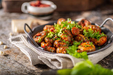 Roasted mushrooms and chilli sauce topped with herbsの写真素材
