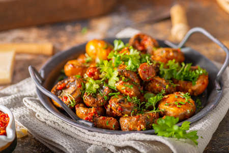 Roasted mushrooms and chilli sauce topped with herbsの写真素材