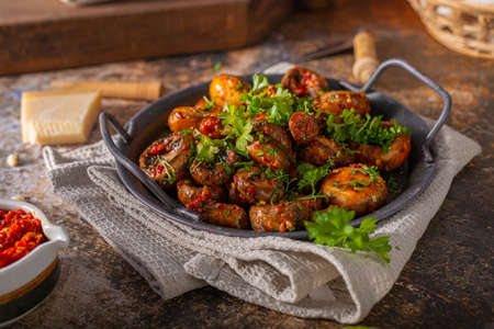 Roasted mushrooms and chilli sauce topped with herbsの写真素材