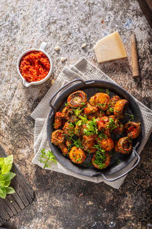 Roasted mushrooms and chilli sauce topped with herbsの写真素材