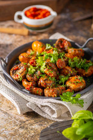 Roasted mushrooms and chilli sauce topped with herbsの写真素材