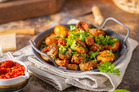 Roasted mushrooms and chilli sauce topped with herbsの写真素材