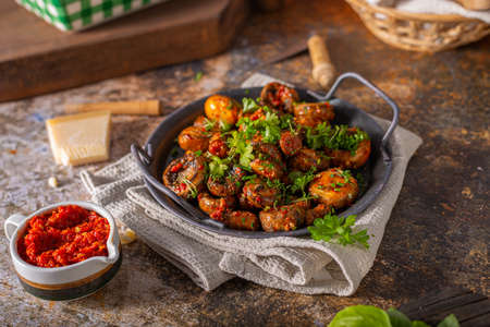 Roasted mushrooms and chilli sauce topped with herbsの写真素材