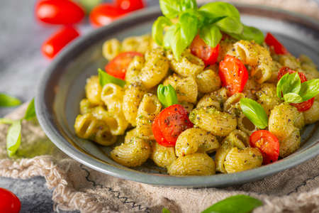 Basil pesto with homemade pasta, roasted tomatoes and parmesanの写真素材